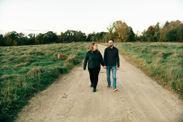 young couple walking on a dirt path in the evning