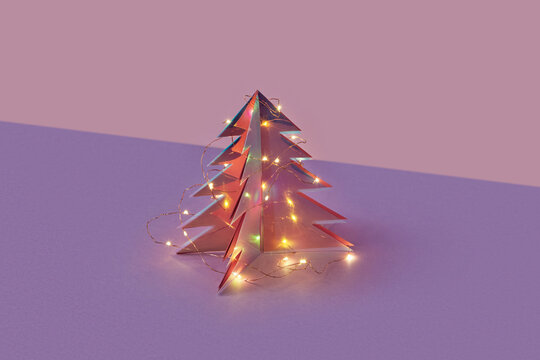 Christmas tree made of plastic and paper adorned in glowing garlands