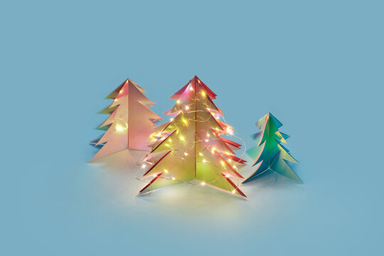 Christmas trees from holographic plastic shining with garlands - Powered by Adobe