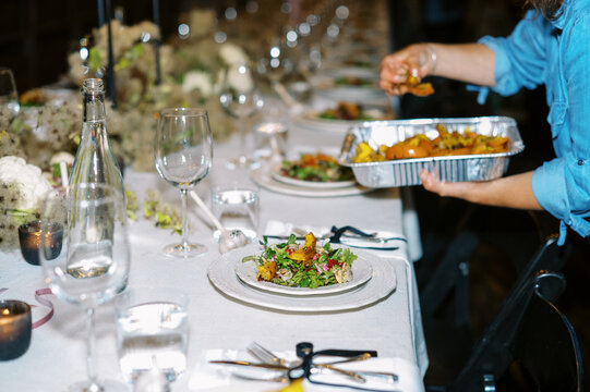 chef of catering company plating salads at dinner party