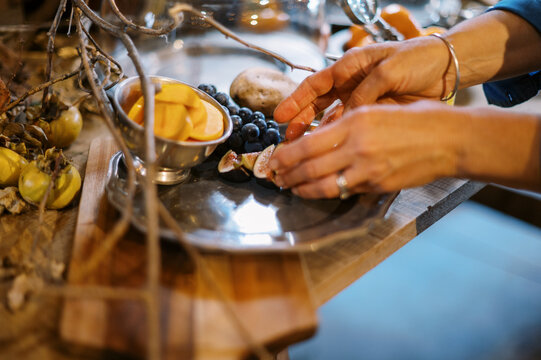 chef placing fresh figs on a pewter platter on an apperizer table