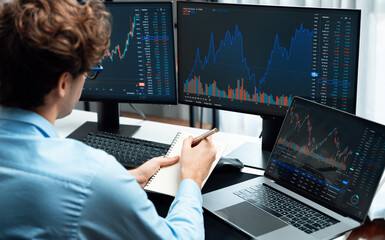 Working young business trader focusing on laptop in market stock graph data investment in real time laptop in screens. at modern office. Concept of analyzing dynamic financial exchange rate. Gusher. - obrazy, fototapety, plakaty