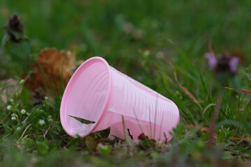 Umweltverschmutzung, kaputter Plastikbecher auf einer Wiese