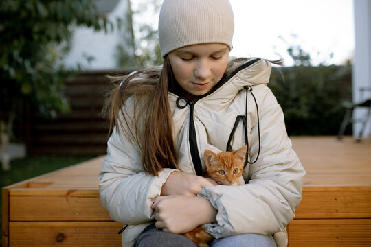 a girl with a red kitten