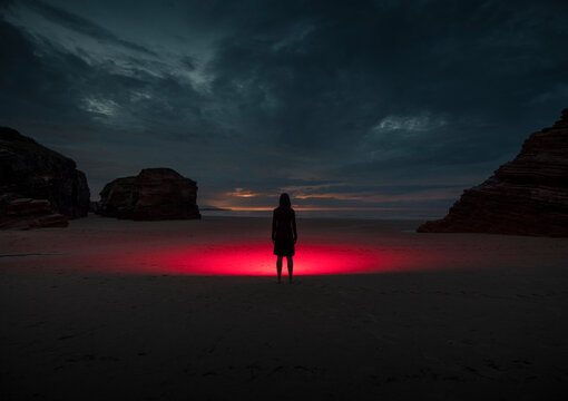 Cinematic silhouette on beach with red light at night