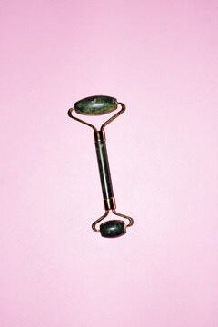 Beauty product photo of  a green jade stone roller 