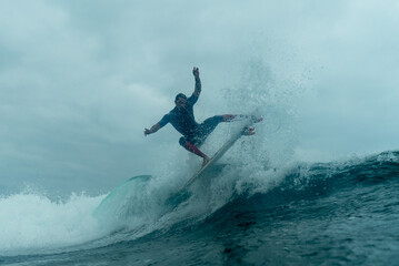 Professional surfer slide over the surface of turbulent waters