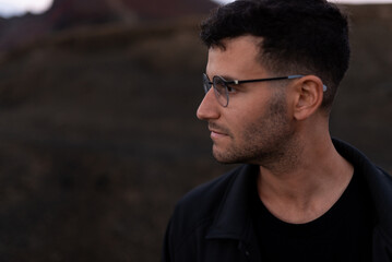 A young model poses looking to his left side