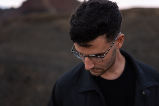 A model poses in a serious manner looking down