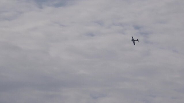 Vintage military airplanes spitfire hawker hurricane in Battle of Britain reenactment flying low in display.
