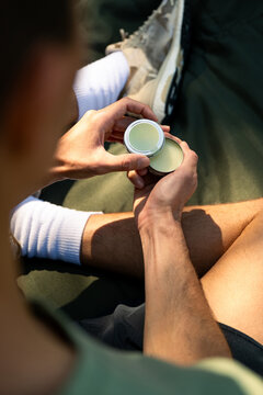 A close-up view of an athlete unsealing a container of CBD balm