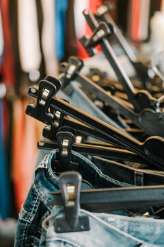 A row of plastic pants hangers at flea market