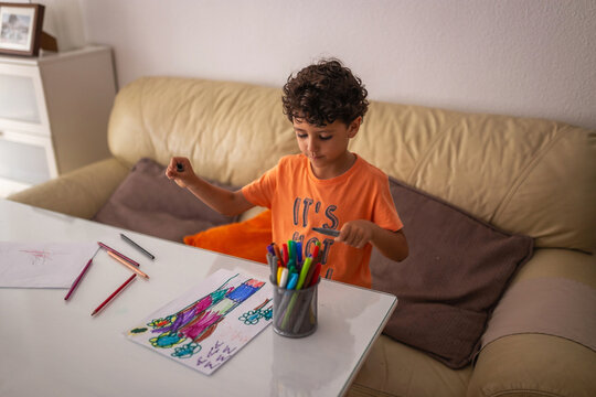 little boy coloring a nice drawing at home