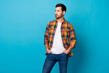 Photo of handsome cool man dressed plaid shirt hands in pockets look at business offer empty space...