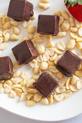 Artisanal Chocolate Treats Artistically Placed Among Roasted Peanuts on Elegant Dish