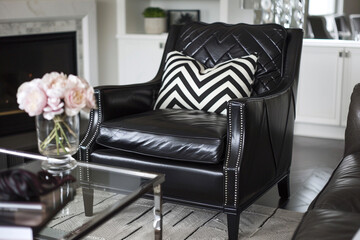 Chic TV lounge in monochrome style, featuring dark leather chair with chevron details and glass table.