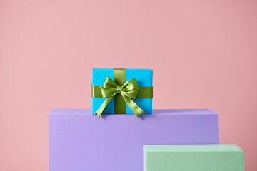 handmade present box on pink background with colors podium