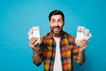 Portrait of overjoyed guy with stubble win bunch of dollar banknotes in lottery astonihsed staring...