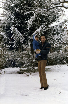 1979. Dad and son pose for a photo in a snowy garden.