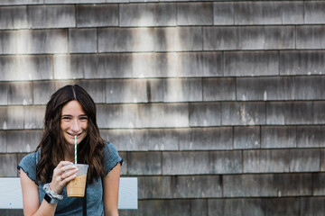 Portrait of young woman drinking iced coffee