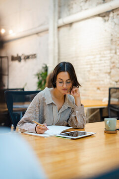 Female Entrepreneur Using Tablet In Modern Workspace