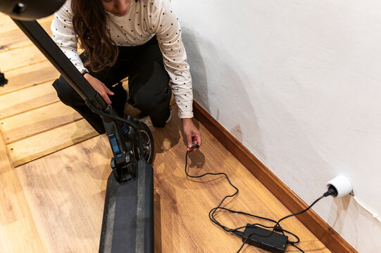 Woman uses charger to recharge her e-scooter battery