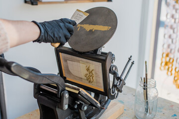 Hands working a letterpress