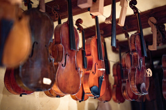 Close-up detail of one of the violins hanging in the master luthier's workshop. Artisan manufacturer of high-end violins