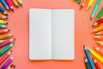 Fototapeta premium photo of a single blank book page centered on the image. on a solid background. with crayons, the vibes are kid-party-friendly