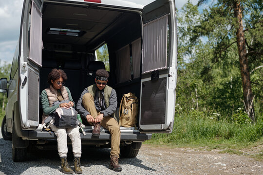 Two Young Travellers Sitting On Minibus Floor