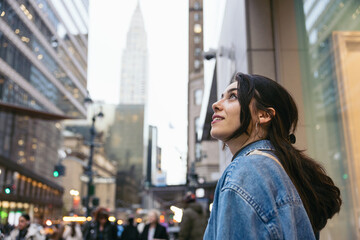 A tourist in New York, looking up in awe at the tall skyscrapers