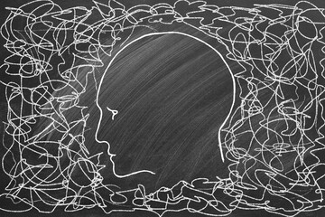 Silhouette of human head with tangled line outside. Illustration on chalkboard. Concept of personality disorder and depression, chaotic thinking, confusion, finding solution