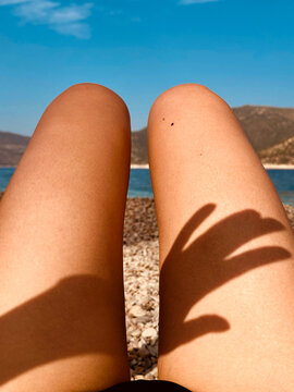 Hand's shadow on woman's legs in sunny day 