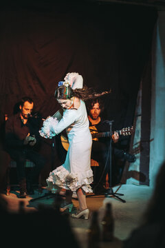 Female flamenco dancer performing on stage with band
