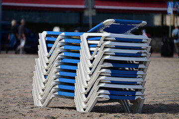 Several blue, stacked sun loungers at the beach of Benidorm-Spain in the morning.