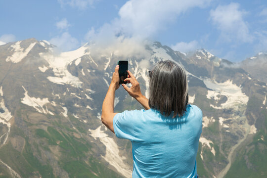 A man taking pictures of the mountains