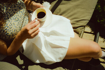 Woman drinking espresso sitting on sun