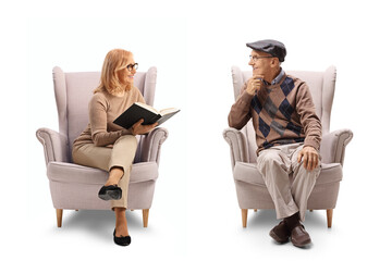 Mature woman holding a book and talking to a man seated in an armchair