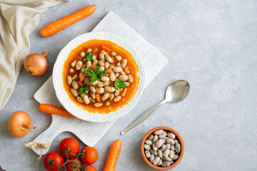Traditional Turkish food kidney beans with olive oil , onion and tomato paste in a ceramic plate on rustic background 