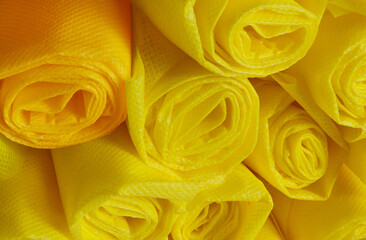 rolls of yellow non-woven fabric with a rough texture. industrial polypropylene material