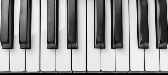 Monochrome close up image of a black and white piano keyboard, showcasing detailed keys