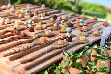 wooden spoons on a wooden background, wooden spoons, wooden spoons on a wooden table, candy table, decoration with wooden coher, party table, birthday party, festive event, party sweets, candy balls
