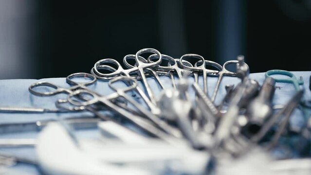 Medical instruments in steel tray on table for surgery. Preparing of surgical tools for a operation. Scalpels and forceps and tweezers. Surgery or emergency case and ambulance or treatment concept