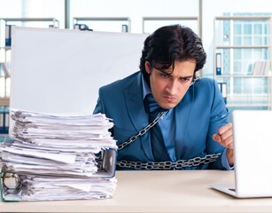 Chained male employee unhappy with excessive work