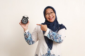 Excited asian elderly woman standing while showing breaking fast time