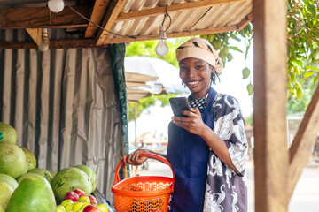 Black Female with Orange Shopping Basket and Mobile Phone - obrazy, fototapety, plakaty