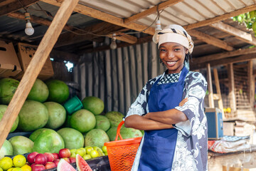 Attractive African Saleswoman at Fruit Stand with Folded Arms