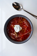 Ukrainian borscht in a bowl on a light background, home cooking