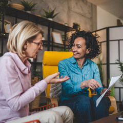 two women work on project at home hold document have consultation