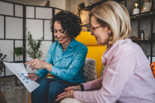 two women work on project at home hold document have consultation